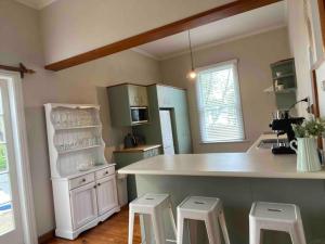 a kitchen with a counter and stools in it at Villa Retreat in Masterton
