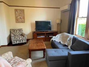 a living room with a couch and a tv at Villa Retreat in Masterton