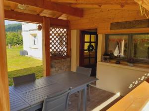 a table and chairs on the porch of a cabin at Appartement cosy à Bussang in Bussang