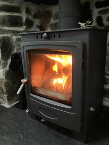 einen Herd mit einem Feuer darin in der Unterkunft Waterfront cottage Applecross Peninsula in Ardheslaig