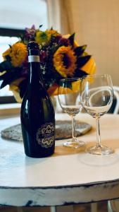 a bottle of wine sitting on a table with two glasses at Chalupa Tri Sýpky in Blatnica +4 photos