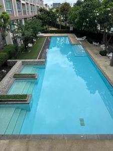 a large blue swimming pool in a building at Baan Peang Ploen Takiab Beach by Cloud9Stays in Hua Hin
