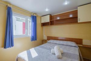 Un dormitorio con una cama grande con cortinas azules. en Bungalow D, en Pontevedra 21 fotos más