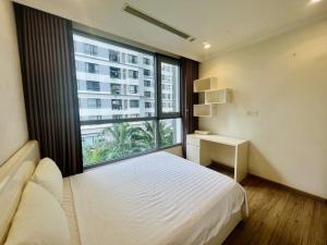 a bedroom with a bed and a large window at BOM HOMES- Vinhomes Timescity-3Br-Luxury Apt in Hanoi