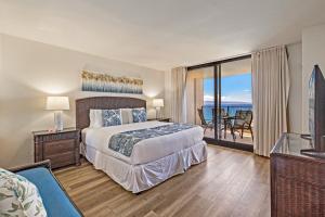 Un dormitorio con una cama y vista al mar. en Mahana 718, en Kahana