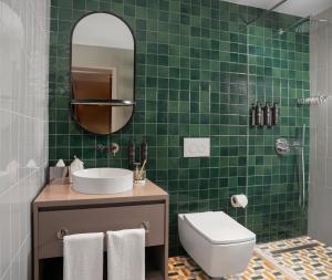 a green tiled bathroom with a toilet and a sink at Casa Foscolo Hotel, Istanbul, a Member of Design Hotels in Istanbul
