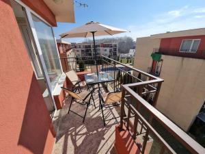 a balcony with a table and an umbrella at Sunny beach family apartment 302, Sluneční pobřeží in Sunny Beach