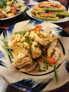 a plate of food with shrimp and vegetables on a table at Rose Merry Guesthouse in Bikaner