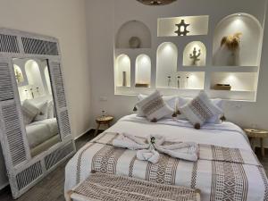 una camera da letto con un letto bianco con asciugamani sopra di RIAD RIME QOUSSAI a Marrakech