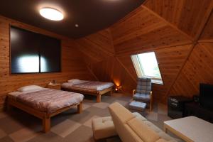 a room with two beds and a tv and a couch at Takahira Base in Yakushima