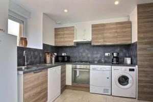 a kitchen with a washing machine and a washer at Gîte du Fournil in Plorec-sur-Arguenon