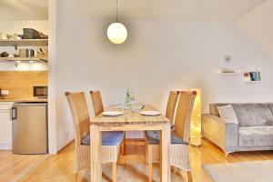 ein Esszimmer mit Tisch und Stühlen und einer Couch in der Unterkunft Seepark Seepark Appartement 36 in Scharbeutz