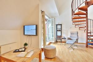 ein Wohnzimmer mit einem Tisch, einem TV und einem Stuhl in der Unterkunft Seepark Seepark Appartement 36 in Scharbeutz