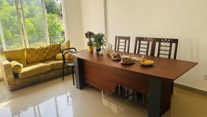 a living room with a wooden table and chairs at Sunrise City Bliss in Sri Jayewardenepura Kotte