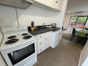 a kitchen with a white stove and a sink at Cosy And Stylish Single Level 2 Bed Home Near CBD in Linwood +18 photos