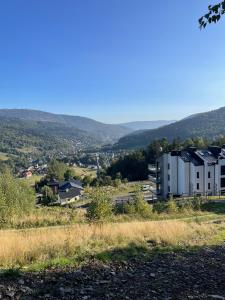een uitzicht op een gebouw vanaf een heuvel bij OWysoko - Apartamenty z Widokiem 200 m od tras Szczyrk Mountain Resort in Szczyrk