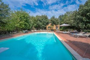 a swimming pool with blue water in a yard at Santa Colomba House, Siena, Nature And Pool in Monteriggioni