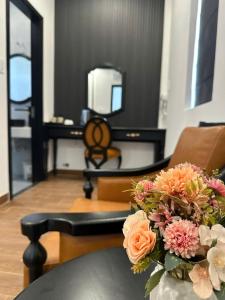 a vase of flowers on a table in a living room at Love Hotel Tô Ký in Ho Chi Minh City +14 photos