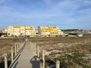 a boardwalk leading to a large building on a beach at Sunny Beach Apartment Holidays in Vila do Conde