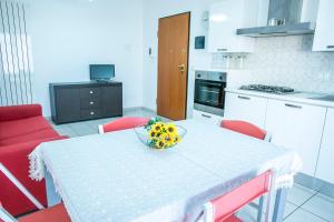 a kitchen with a table with a bowl of fruit on it at Ficus Pineto Vacanza in Pineto