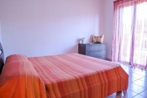 a bedroom with a bed and a dresser and a window at Ficus Pineto Vacanza in Pineto