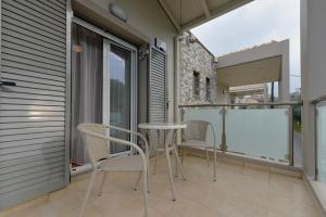 a balcony with two chairs and a table at Avia Blue Maisonettes - Messinia Gulf Retreat in Avia