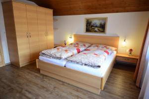 1 dormitorio con 1 cama en una habitación con suelo de madera en Ferienwohnung Bernsteiner, en Iselsberg