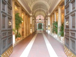 an empty hallway in a building with plants at Artemis in Rome