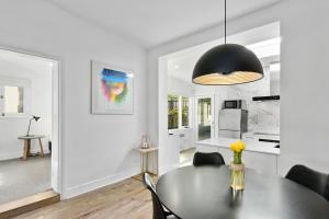 a dining room with a table and a black lamp at Hampden Neuve - Luxury Georgian Cottage in Hobart