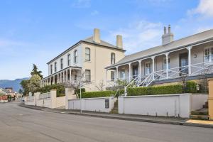a large white building on a street next to a road at Hampden Neuve - Luxury Georgian Cottage in Hobart