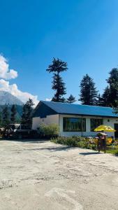 a building with a car parked in front of it at Relax Cottages & Resort Kalam in Kalām