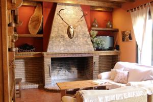 een woonkamer met een stenen open haard met een klok bij Casa Rural El Bonito in Cazalla de la Sierra