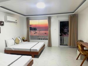 a bedroom with a bed and a view of the ocean at Krabs Dive Resort in Sabang