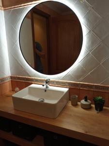 La salle de bains est pourvue d'un lavabo et d'un miroir rond. dans l'établissement Calpe Beachfront Apartment, à Ifach