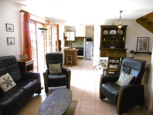 un salon avec un canapé et des chaises et une cuisine dans l'établissement Maison 4 pièces 6 personnes proche de la mer - WIFI - SOAZIG, à Saint-Gildas-de-Rhuys