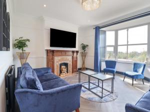 a living room with a blue couch and a fireplace at Gwynfa in Barmouth
