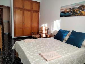 a bedroom with a bed and a cabinet and a chair at APARTAMENTOS La PEÑA D in La Guancha
