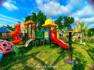a group of playground equipment in a grass field at Thisak Resort Cheung phnom kulen in Siem Reap