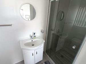 a white bathroom with a sink and a shower at Silver Oaks Where The Clock Stops in Langebaan