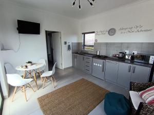 a kitchen with a table and a table and chairs at Silver Oaks Where The Clock Stops in Langebaan +37 photos