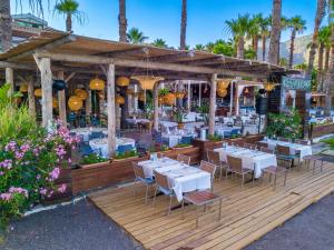 a restaurant with white tables and chairs on a wooden deck at Hotel Ekincik in Ekincik +48 photos