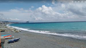 a beach with boats on the shore of the ocean at ANFORA HOUSE in Genoa