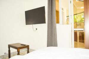 a bedroom with a bed and a tv on the wall at Raica enterprises in Nyali