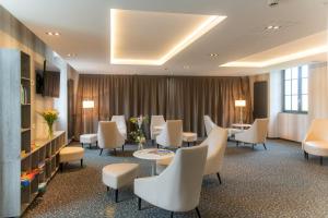 a waiting room with white chairs and tables at Résidence Goélia Le Domaine de Pont-Aven in Pont-Aven