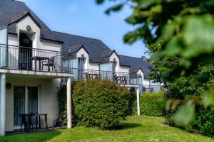 a row of white houses with black balconies and chairs at Résidence Goélia Le Domaine de Pont-Aven in Pont-Aven