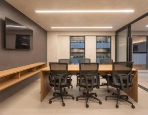 a conference room with a wooden table and chairs at Beach Haus beira mar bessa in Tambaú +18 photos