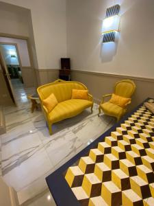 a living room with yellow furniture and a checkered floor at Cozy Luxury Room Pantheon in Rome