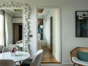 a dining room with a white table and a mirror at Sofitel Roma Villa Borghese in Rome