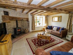 Una sala de estar con un sofá y una chimenea. en Grove Farm, en Church Stretton