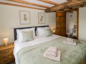 Un dormitorio con una cama grande con toallas. en Grove Farm, en Church Stretton
